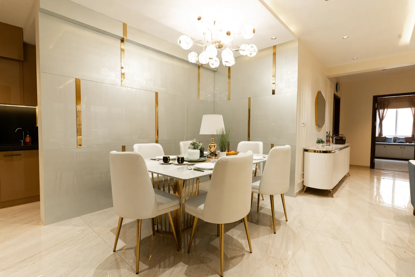 Dining room with white chairs, gold-inlay wall panels and chandelier — Arna's Home